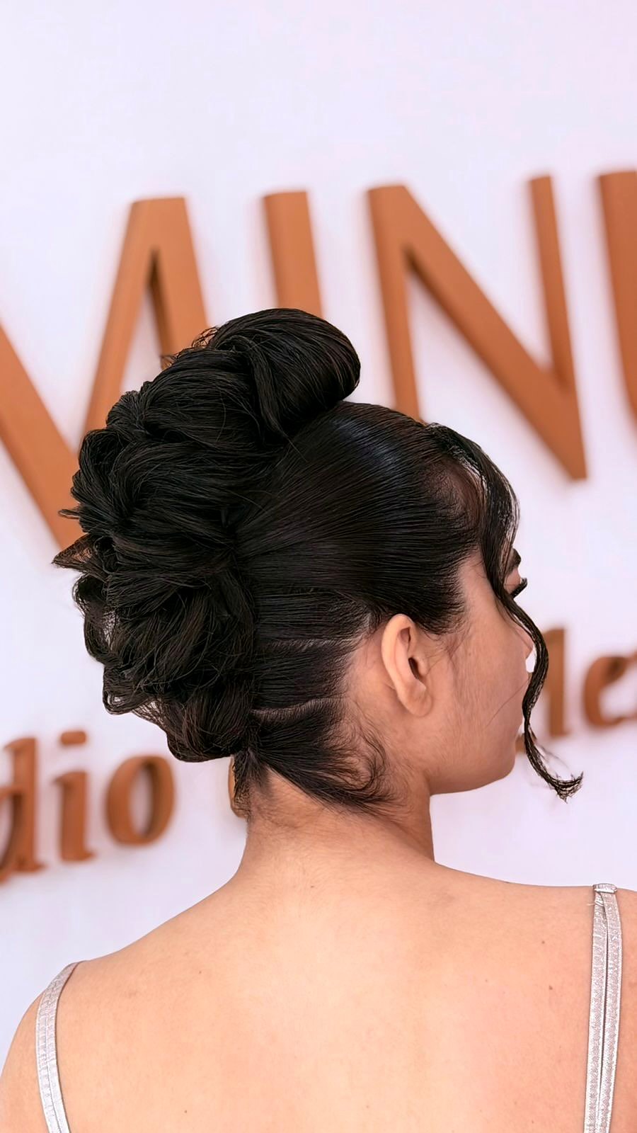Penteado de coque feito no estúdio, diante da parede Luminus